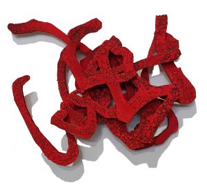 Abstrakti seinälle ripustettu veistos, joka koostuu punaisista mutkittelevista viivamaisista linjoista.