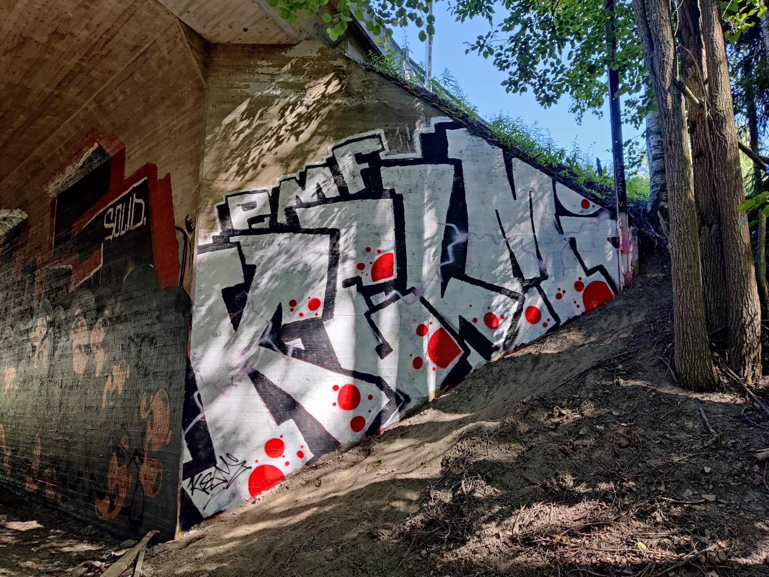 Alikulkutunnelin pääty, johon on maalattua valkomusta graffiti.