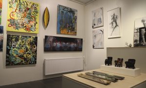 Tila, jossa on useita teoksia ripustettuna.