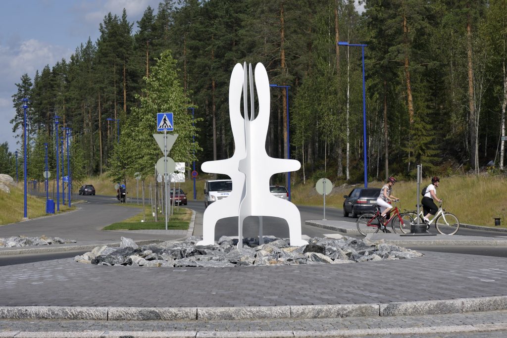 Liikenneympyrä, jonka keskellä on abstrakti valkoinen jänistä esittävä veistos.