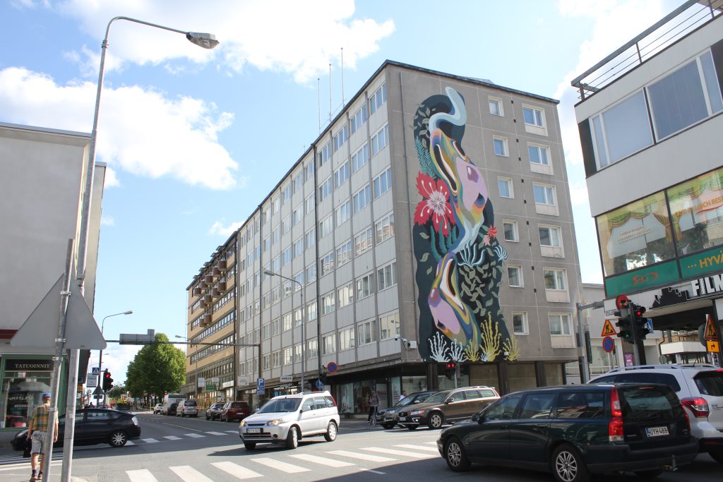 Kuopion keskustan kerrostalo, jonka päätyyn on maalattu suurikokoinen muraaliteos.