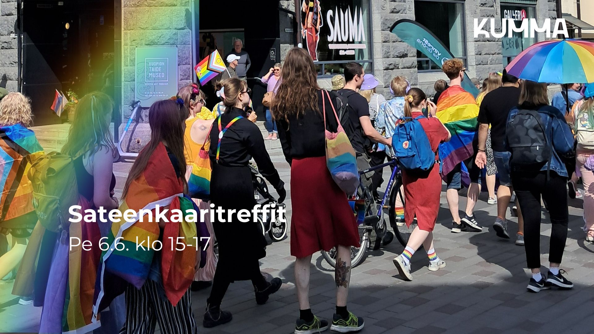 Kuvassa on Pride-kulkue kulkemassa KUMMAn ohi. Kulkueessa kulkevat ihmiset ovat pukeutuneet värikkäisiin, sateenkaaren värisiin vaatteisiin ja asusteisiin. Kuvassa lukee "Sateenkaaritreffit pe 6.6. klo 15-17" ja kuvassa on KUMMAn logo.